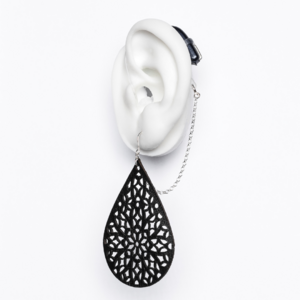 White ear mould shows large black teardrop shaped earring with cut out pattern